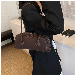 Detail of dark brown tote bag with white contrast stitching and double zipper closure