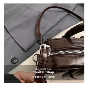 Detail of adjustable shoulder strap and silver buckle on dark brown glossy bowling bag