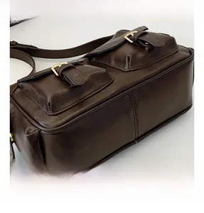 Detail of dark brown retro tote bag featuring double pockets and gold buckle hardware