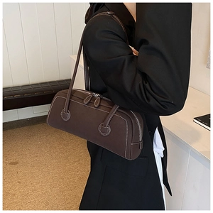 Model wearing a vintage dark brown bowling tote bag with white contrast stitching details