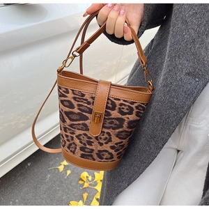 Detail of leopard print bucket bag with brown leather trim and gold metal clasp