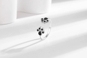 Close-up of adjustable silver ring with black enamel cat paw print design