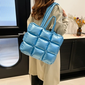 Blue quilted puffer tote bag with glossy finish and large padded squares for women
