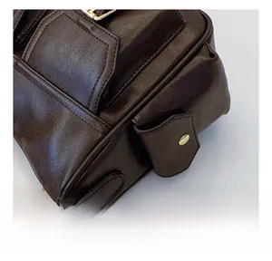 Detail of durable gold zippers and textured brown faux leather stitching on tote bag