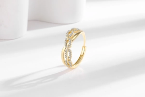 Close-up of golden chain link ring with micro-pave white zircons and open design