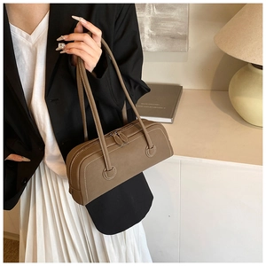 Close-up of brown leather tote bag with contrast stitching and double handle detail