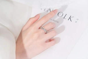 Macro detail of criss-cross interlocking ring with pavé zircons on model hand