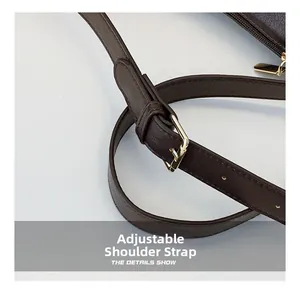 Detail of dark brown leather adjustable shoulder strap with golden buckle and eyelets