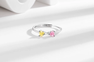 Macro d'une bague en argent avec pierres en forme de cœur jaune citron et rose cerise