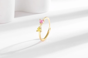 Détail de la bague dorée ajustable avec zircons en forme de cœur rose et jaune