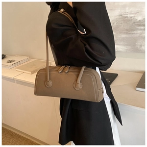 Detail view of brown retro tote bag with white contrast stitching and dual zippers