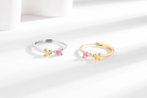Détail de pierres de zircon en forme de cœur jaune et rose sur une bague ajustable