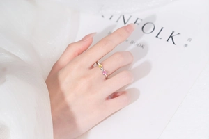 Gros plan d'une bague en argent avec deux pierres en forme de cœur au doigt