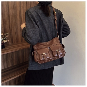 Retro brown leather tote bag with dual front pockets shown from a model side view