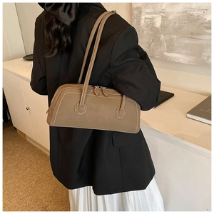 Detailed close-up of taupe tote bag with white contrast stitching and dual zipper closure