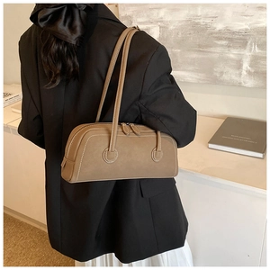 Detail of vintage brown leather bowling tote bag featuring contrast white stitching