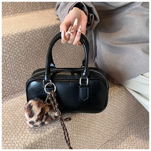 Detail of black textured leather bowling bag with silver hardware and leopard heart charm