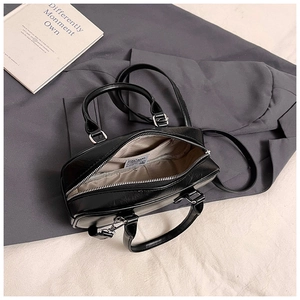 Detailed interior of a black leather bowling bag showing inner pocket and fabric lining
