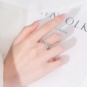 Crossed chain silver ring with zircon stones worn by a model in a minimalist lifestyle setting