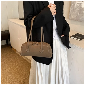 Detail of a brown leather tote with white contrast stitching and double zipper closure
