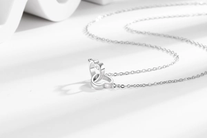 Macro shot of silver interlocking double heart pendants on a fine link chain necklace