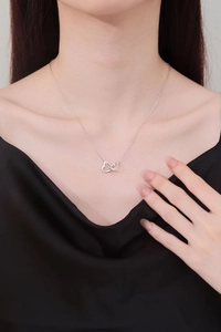 Close-up of interlocking double heart silver necklace worn on model for a stylish look