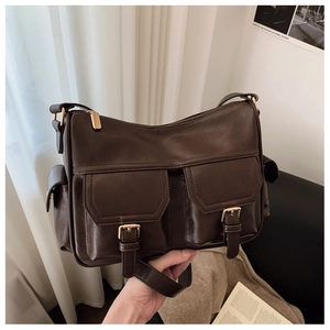 Detail of vintage dark brown tote bag featuring dual front pockets and gold metal buckles