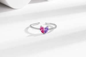 Detail of twisted silver band ring with pear-cut pink and violet crystal gemstones