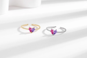 Macro view of pear-cut pink and purple gemstone rings with gold and silver rope bands