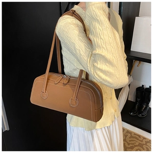Detail of brown leather tote bag with white contrast stitching and double zippers