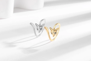Detailed close-up of adjustable silver and gold fox rings with black gemstone eyes