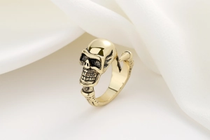 Macro shot of vintage gold skull ring with gothic bone textures and antique finish