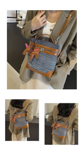 Dettaglio della borsa a cilindro in denim e pelle con ciondolo a cavallo in un caffè