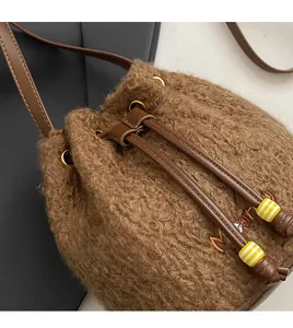 Detail of plush wool bucket bag featuring leather drawstrings with striped bead accents