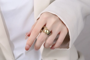 Macro detail of men's vintage gold skull ring with claw design worn by a model