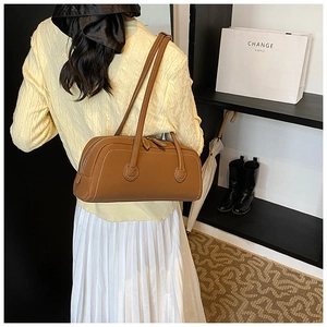 Brown leather tote with white contrast stitching styled with a yellow sweater and skirt