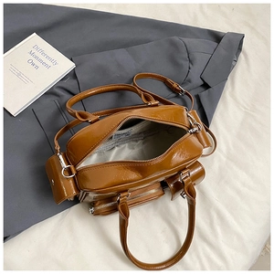 Detailed top view of caramel faux leather bag interior with grey lining and metal zipper