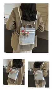 Tre viste di una borsa in denim celeste con un ciondolo in pelle a forma di cavallo