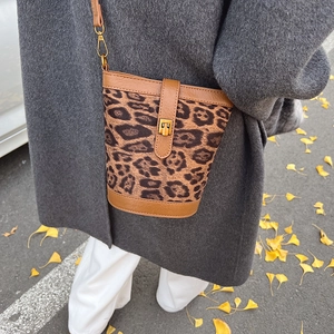Vintage leopard print bucket bag for women styled with a grey coat in autumn scenery
