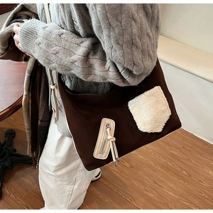 Detail of crossbody tote bag with brown textured fabric and white fleece front pocket