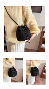 Detail of black fuzzy bucket bag with drawstring closure and yellow bead accents