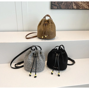 Detail of wool fabric bucket bags in brown, grey, and black with drawstring closure