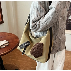 Detail of hobo bag featuring olive nylon fabric and brown shearling patchwork accent