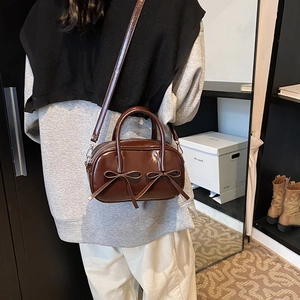 Brown patent leather bowling bag with twin bows and a detachable shoulder strap