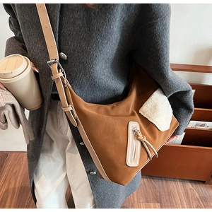 Detail of brown frosted leather tote bag with white faux fur patch and long tassels