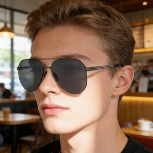 Klassische Pilotenbrille mit dunklen Polgläsern und grauem Metallrahmen an einem männlichen Model