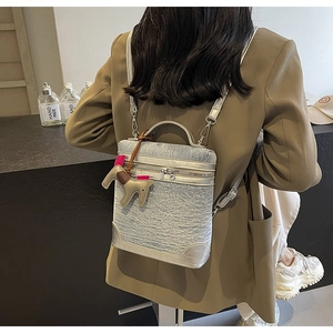 Dettaglio della mini borsa in denim azzurro con ciondolo a forma di pony e tracolla argento