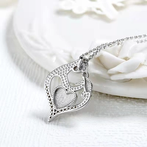 Silver heart pendant necklace showing a mother and child embrace with zircon accents