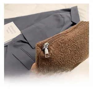 Close-up of brown faux shearling handbag showing premium silver metal zipper and soft texture