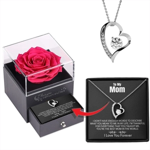 Détail de collier cœur en argent avec cristal dans un coffret cadeau rose de luxe